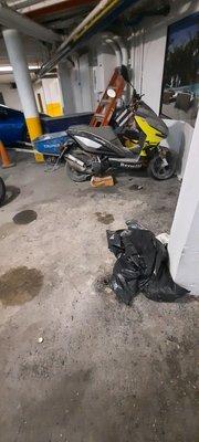 The motorcycle parking area is filthy and oily.