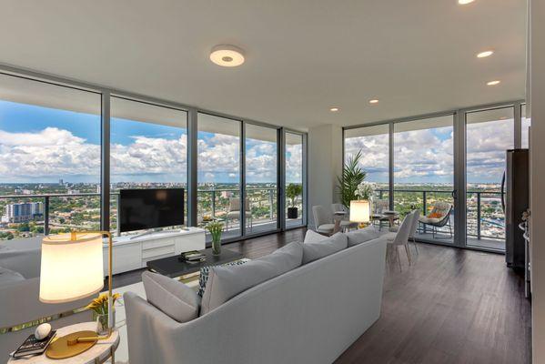 Spacious living room with floor to ceiling windows for ample natural light and wood plank style flooring at Lantower River Landing.