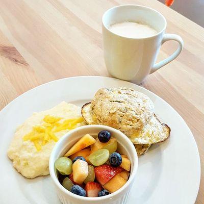 Homemade cheddar and chive biscuit, all natural sausage, free range eggs, American Cheddar, garlic grits and marinated fruit!!