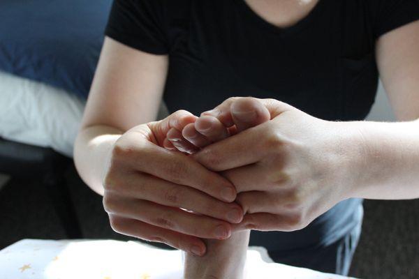 Massage therapist stretching a client's foot