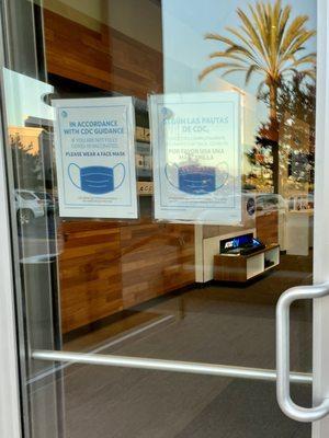 Outside: door signage reminding non-vaccinated customers to wear masks