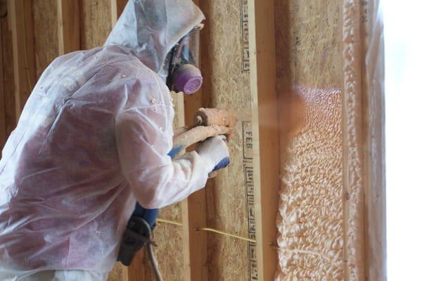 Spraying a wall with Closed Cell Foam to form an air and vapor barrier.