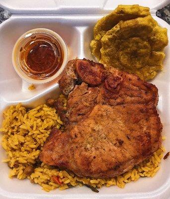 Chuleta (Pork chop) and arroz con gandules (rice with pigeon peas) and tostones.