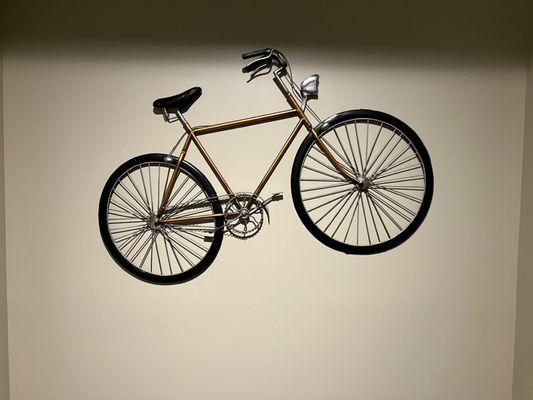 One of the wire frame bicycles hanging on the wall.