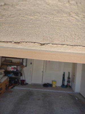 Board not nailed properly and causing stucco to fall off on the top of garage