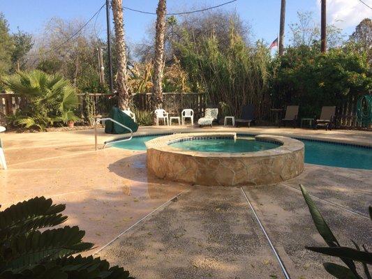 Leisure time by the pool includes a hot tub as well.