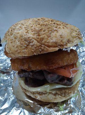 Filet Mignon Sandwich with extra Provolone Cheese, Lettuce, Tomato and an order of Onion Rings on a round seeded Sarcone Roll.