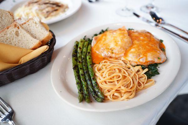 Veal Saltimbocca - veal scallopini topped with prosciutto, sage and melted fontina cheese on a bed of spinach topped with tomato sauce.