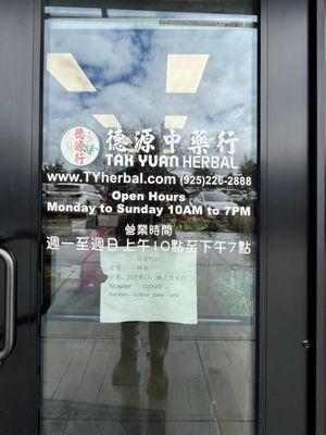 Door showing hours, website, and phone number.