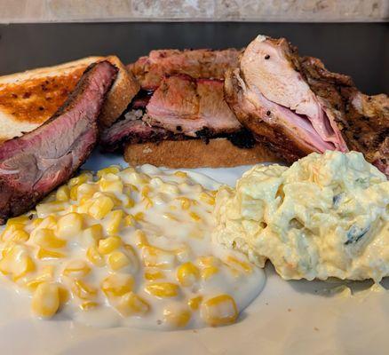 Pork ribs, bread with BBQ sauce, brisket on bread, chicken, creamed corn, potato salad