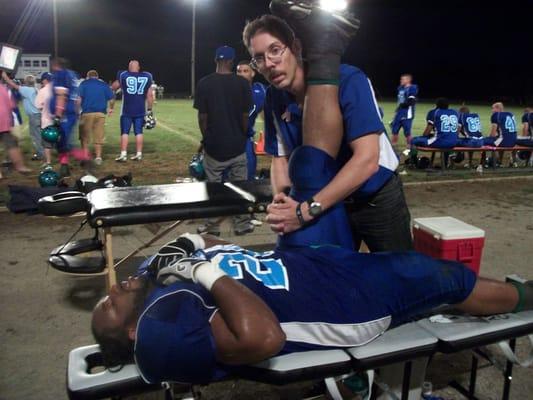 Dr. Austin stretching a Foxes player's hamstring on the sidelines.