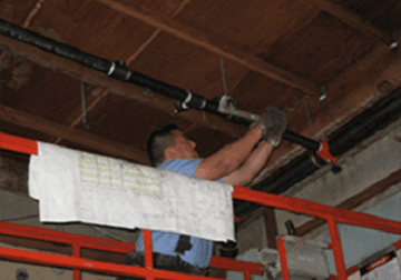 Technician installing a sprinkler line on a commercial project.