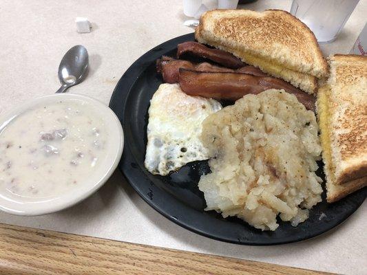 Egg, bacon, toast, potatoes, and sausage gravy