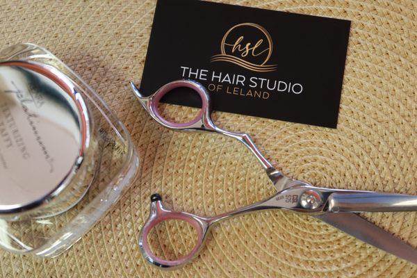 Scissors next to a business card that reads, "Hair Studio of Leland"