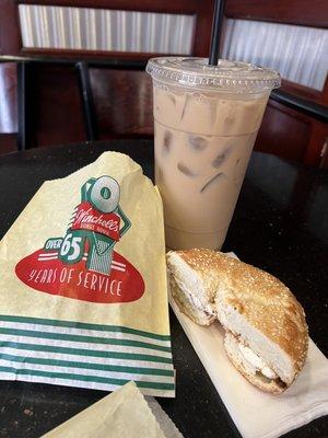 Fresh sesame bagel toasted with cream cheese and a large vanilla iced coffee.