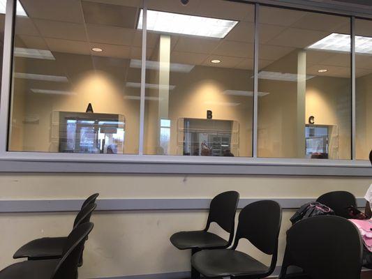 The waiting area and the service windows behind the glass marked A, B, C.