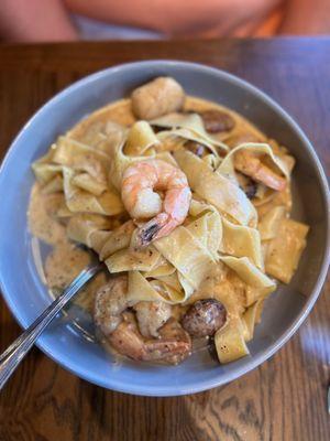 Shrimp, scallop and spicy sausage in a spicy cream sauce over homemade pasta