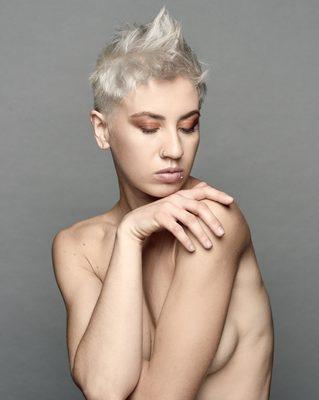 [Natalia] Go Bold with a cropped pixie. Edgy texturized top with short tapered sides. A double process hair color of platinum blonde.