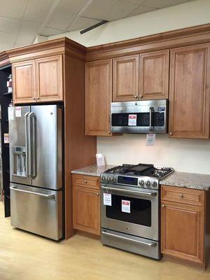 kitchen showroom with wooden cabinets and stainless steel kitchen appliances on display