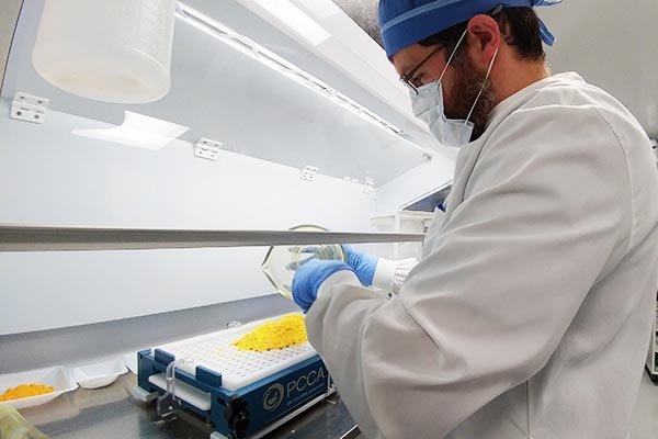 Travis making capsules in our compounding lab.