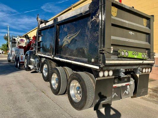 A heavy duty to truck towing a dump truck.