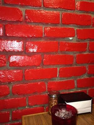 The brick wall is painted red! High schoolers names have been covered.