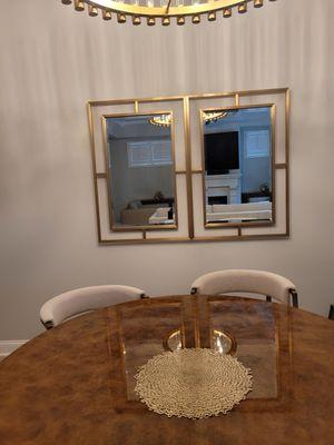 2 Decorative designer Mirrors mounted side by side on painted drywall in formal dining room.