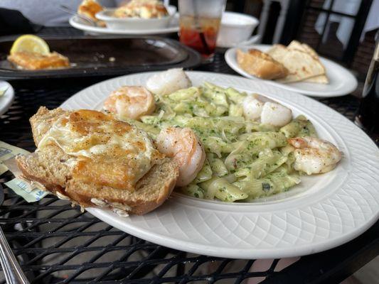 Saganaki with sea scallops and shrimp, over pesto penne.