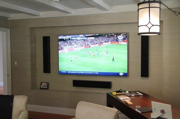 Plasma TV with center channel and left and right speakers.