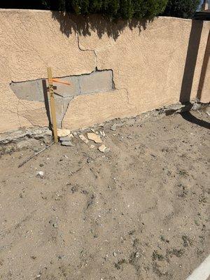 Wall was previously cracked but now has further damage to wall and trash was spread to sidewalk