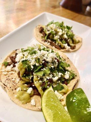 Asada Taco - Marinated skirt steak topped with onions, cilantro, salsa de aguacate, and queso fresco