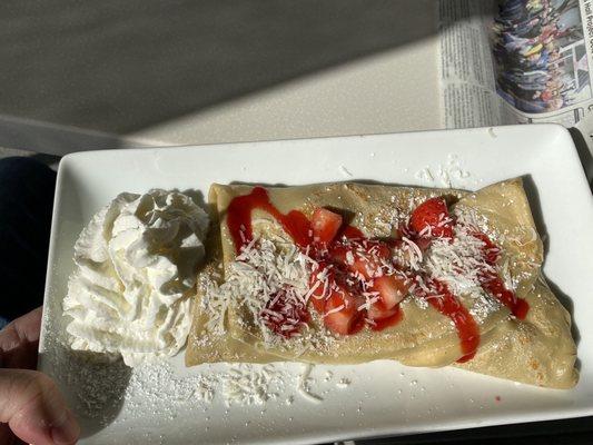 Strawberry Shortcake Crepe with raspberry sauce, coconut flakes, and whipped cream.