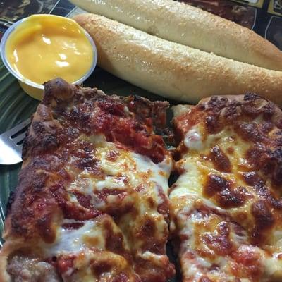 Sausage pizza slice with breadsticks