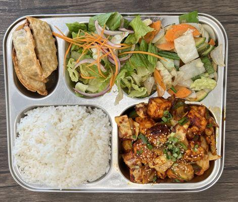 Platter with spicy tofu, white rice, Veggie Dumplings, salad, & Stir Fried Veggies