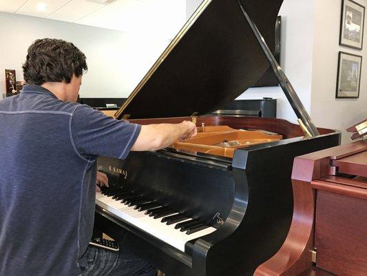 Anthony preparing a baby grand piano for a local jazz pianist.