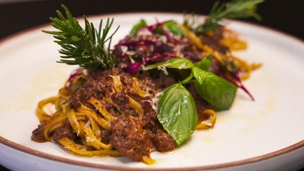 Tagliatelle Bolognese made with beef, cured prosciutto, sofritto, herbs and parmigiano