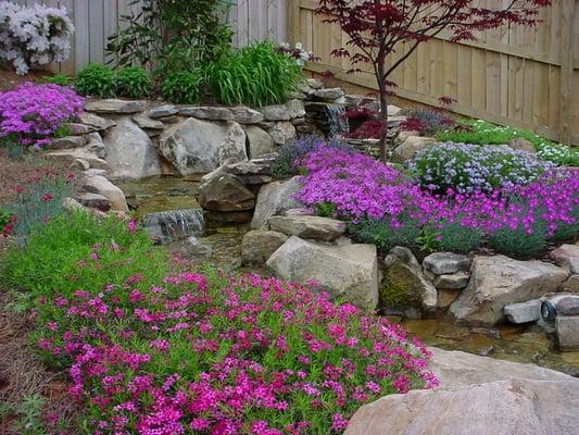 Creeping Phlox, Dianthus, and Day lilies grace the edges of the streams