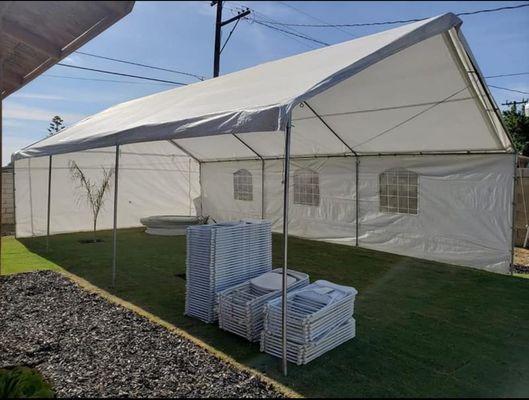 Canopy with sides covered. 
Round tables and white regular chairs.