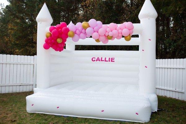 Luxury White Castle bounce house with balloon garland and customizable garland.