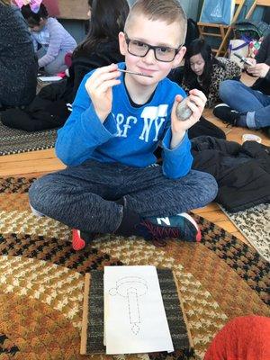 My son getting ready with his "hammer and punch", to make a tin punch project.