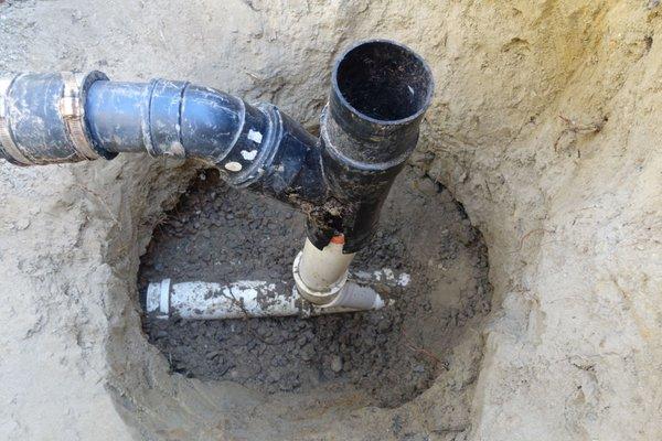 Sewer pipe in front lawn showing misfit of Tee and vertical pipe of wrongly thin material cracked and had root ingress.