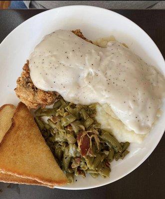 Chicken fried steak with green beans and mashed potatoes.