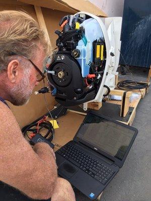 Setting up on the laptop a brand new Evinrude ETEC outboard motor.