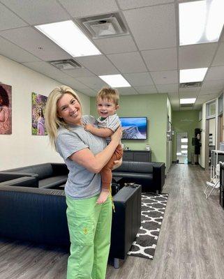 Kelly holding a toddler who came to visit. She helped him breastfeed back in 2021 when we first opened. (Shared with permission)