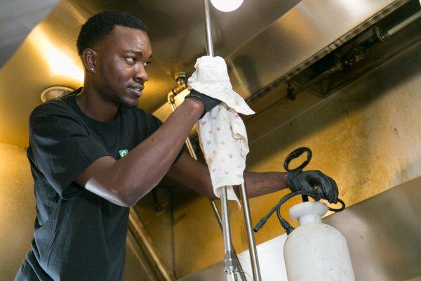 Guardian Technician cleaning a fire suppression component.