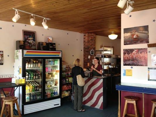 Counter, seating, and cooler for drinks, sides, and desserts.