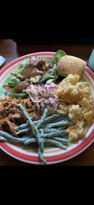 A little bit of everything; salad, roll, macaroni and cheese, green bean casserole, pulled pork, and coleslaw