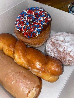 Maple bar, glaze twist, sugared donut, chocolate donut with sprinkles, and lemon jelly filled with powdered sugar.