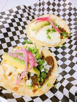 Chorizo and bean taco. With a fried egg, avocado cilantro, and onions.