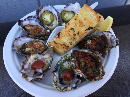 Grilled oysters with different sauces like garlic butter, pickled jalapeños